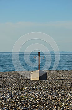 Christian cross crucifix on rocky Black Sea beach seafront Batumi Georgia