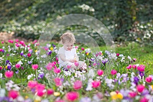 Bautiful funny baby girl playing in field of flowers photo