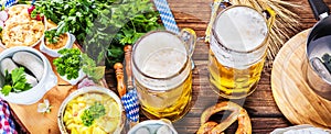 Bavarian beer with soft pretzels, wheat and hop on rustic wooden