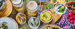 Bavarian beer with soft pretzels, wheat and hop on rustic wooden