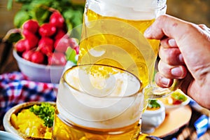 Bavarian beer with soft pretzels, wheat and hop on rustic wooden