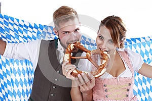 Bavarian couple in traditional costume with beer and brezel