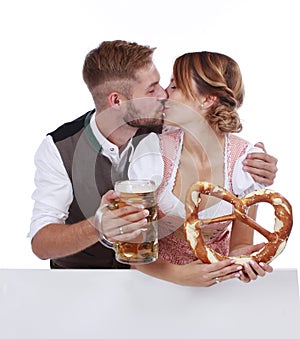 Bavarian couple in traditional costume with beer and brezel