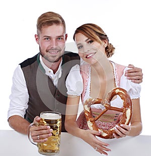 Bavarian couple in traditional costume with beer and brezel