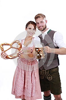 Bavarian couple in traditional costume with beer and brezel