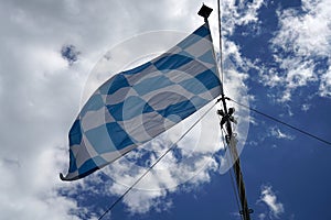 Bavarian flag flies against a blue white sky on a summer day in Bavaria