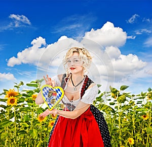 Bavarian girl in tracht dress dirndl in sunflower field