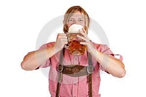 Bavarian man drinks out of oktoberfest beer stein