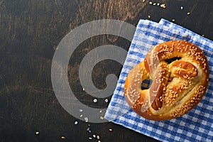 Bavarian pretzels and glass of lager beer. Oktoberfest food menu, traditional salted pretzels over old dark wooden background. Top