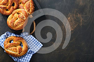 Bavarian pretzels and glass of lager beer. Oktoberfest food menu, traditional salted pretzels over old dark wooden background. Top