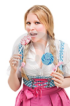 Bavarian woman in dirndl, holding lollipop.
