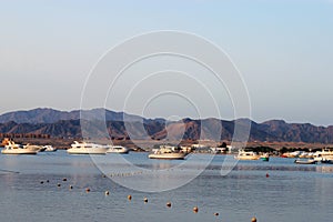 Bay and boats on the water. Low mountains in the distance. Resort on the Red sea coast, Egypt