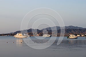 Bay and boats on the water. Low mountains in the distance. Resort on the Red sea coast, Egypt