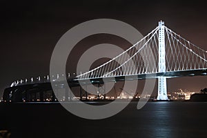 Bay Bridge Illuminated in the Night and East Bay in the Backdrop