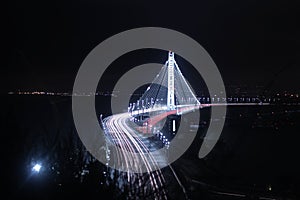 Bay Bridge Illuminated in the Night and East Bay in the Backdrop