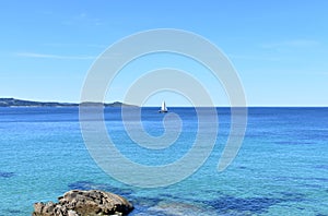 Bay with clear water and sailing boat. Sunny day, Rias Baixas, Spain.