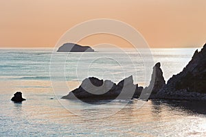 Bay with irregularly shaped rocks at sunset.