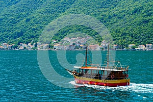 bay of Kotor with cruise ship for sea trip, Montenegro, bright sunny day, mountains and small towns on the coast, summer travel