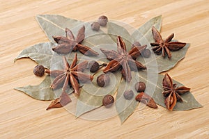 Bay leaf, allspice, and star anise on a wooden table