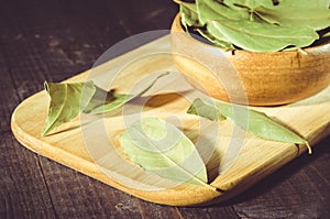 Bay leaf on a tray in a wooden bowl/bay leaf in a wooden plate on a tray, rural style