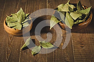 Bay leaf in a two wooden bowl/spices of bay leaf in rural style on a wooden background