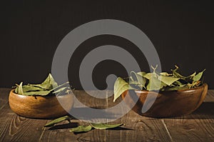 Bay leaf in a two wooden bowl/spices of bay leaf in rural style on a wooden table. Copy space