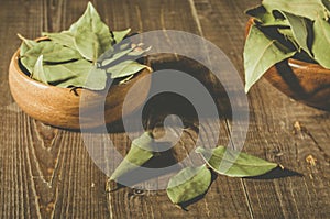 bay leaf in a two wooden bowl/spices of bay leaf in rural style on a wooden table. selective focus