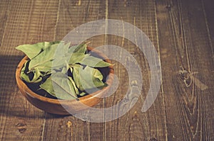 bay leaf in a wooden bowl/bay leaf in a wooden bowl on a wooden background. Copy space