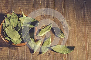 Bay leaf in a wooden bowl/bay leaf on a wooden surface. Top view. Copy space