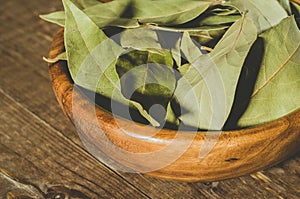 bay leaf in a wooden plate/bay leaf in a wooden plate on a wooden background. Close up