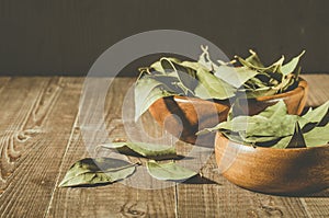 Bay leaf on a wooden surface in a two wooden bowl/spices of bay leaf in rural style on a wooden table. Copy space
