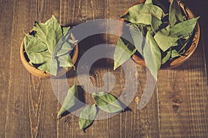 bay leaf on a wooden surface in a two wooden bowl/spices of bay leaf in rural style on a wooden table. Top view