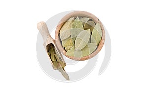 Bay leaves in wooden bowl and scoop isolated on white background. top view. Spices and food ingredients