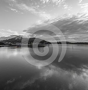 Bay waterscape with reflections in monochrome