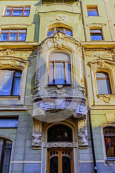 Bay window, windows, masks, stucco and architecture of a very old building in the Empire style. Moscow, Petrovsky Pereulok 8.