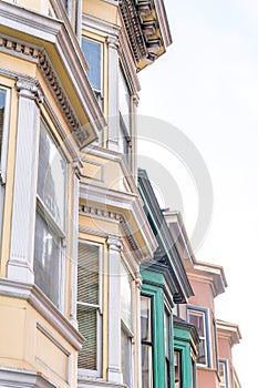 Bay windows of victorian townhouses against the white sky background at San Francisco, CA