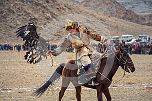 Bayan-Ulgii, Mongolia - October 01, 2017: Golden Eagle Festival. Mongolian Hunter Berkutchi In Traditional Clothes With A Golden E