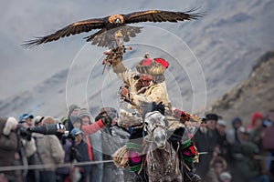 Bayan-Ulgii, Mongolia - October 01, 2017: Golden Eagle Festival. Triumphant Mongolian Hunter Berkutchi In Traditional Clothes Ridi