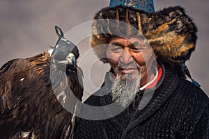 Bayan-Ulgii, Mongolia - October 01, 2017: Traditional Golden Eagle Festival. Old Greybearded Mongolian Hunter Berkutchi With G