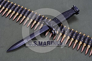 bayonet and ammunition belt on US MARINES uniform background