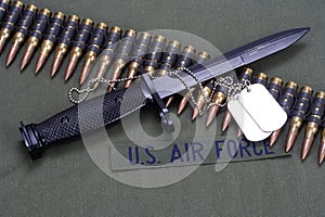 bayonet, dog tags and ammunition belt on US AIR FORCE uniform background