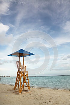 Baywatch chair in a beautiful beach empty at summer sunset.