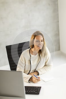 Bbeautiful businesswoman working on laptop in bright modern office