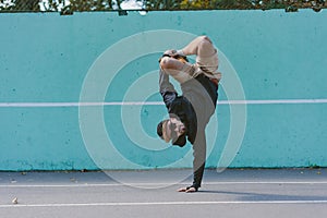 BBOY dancing breakdance against a blue wall photo