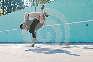 BBOY dancing breakdance against a blue wall