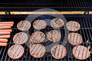 BBQ burgers prepared on a barbecue fire flame grill with beef meat