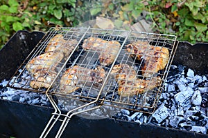 BBQ chicken wings on smoking grill over hot coals