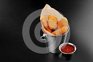 BBQ fried chicken naggets in a metal bucket onblack background with sauce food m photo