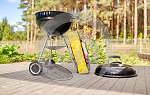 Bbq grill brazier and bag of charcoal outdoors photo