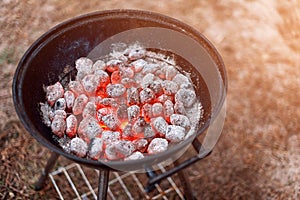 BBQ grill with glowing and flaming hot charcoal briquettes, closeup, top view.